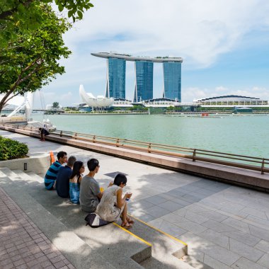 Tourists sit in park at Singapore business buildings area