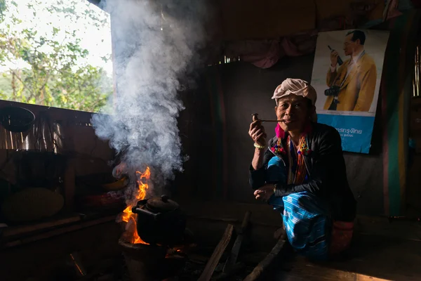 Karen Hill Tribu 'sta fumando tabacco da pipa con vestiti tradizionali e luce drammatica — Foto Stock