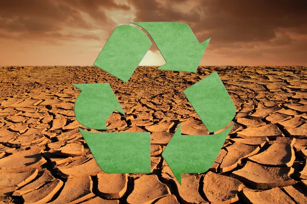 Símbolo de reciclaje en la textura del suelo seco y el fondo del cielo . — Foto de Stock