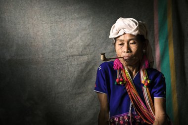 Karen hill kabile tütün boru ile geleneksel giysiler ve dramatik ışık sigara içiyor