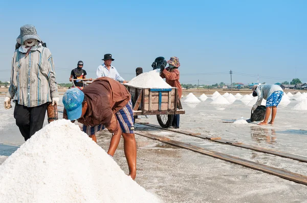 Unidentified workers carrying salt at salt farm on March 07, 2010 in Chonburi Thailand. Chonburi is the main industrial area in Thailand — Stock Photo, Image