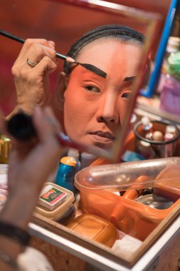 Bir Çin opera oyuncu boyama maskesi performansına Bangkok'un mahallesinde büyük Tapınak, sahne arkasında 16 Ekim 2015 Bangkok, Tayland için önce yüzünde