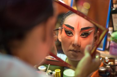 Bir Çin opera oyuncu boyama maskesi performansına Bangkok'un mahallesinde büyük Tapınak, sahne arkasında 16 Ekim 2015 Bangkok, Tayland için önce yüzünde
