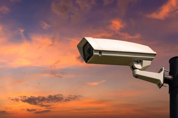 Single CCTV Security camera on beautiful sunrise sky and clouds — стокове фото