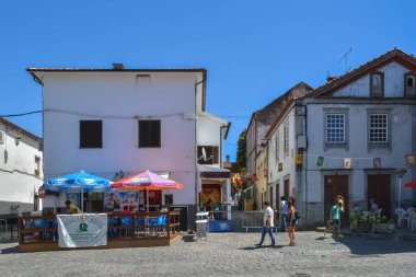 Belmonte / Portekiz - 08 / 14 / 2014: Belmonte Village Downtown 'da klasik binaların bulunduğu bir sokakta turistler yürüyor ve anıt binaları ziyaret ediyorlar