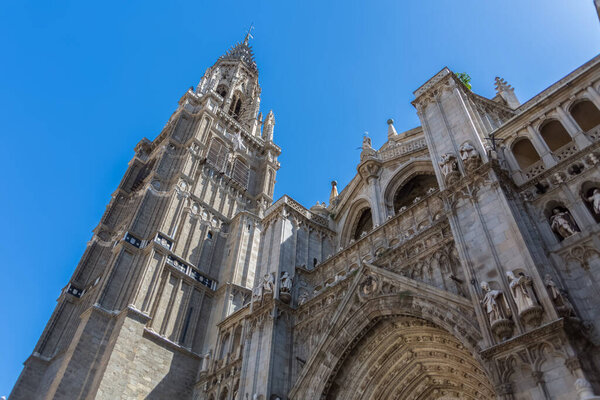Толедо / Испания - 05 12 2021: Детальный вид на здание готического памятника Примас-собор Святой Марии Толедской, украшения и башня на заднем плане