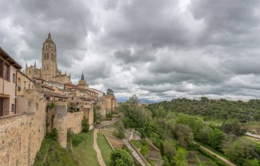 Segovia / İspanya - 05: 13 2021: Segovia şehir kalesi ve çevresindeki bitki örtüsünün görkemli manzarası, Segovia katedralindeki İspanyol gotik binası, kulesi
