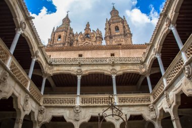 Salamanca / İspanya - 05 12 2021: Arkaplan olarak Salamanca 'daki Casa de las Conchas binası ve La Clerecia binası, Pontifical Üniversitesi' ndeki muhteşem manastır manzarası