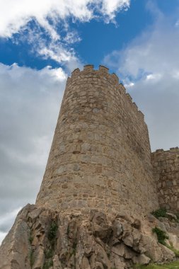Avila / İspanya - 05: 12 2021: Avila şehir surları ve kale kulesi, arka plan olarak mavi gökyüzü