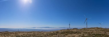 Caramulo dağlarının tepesinden panoramik ve inanılmaz bir manzara. Serra da Estrela dağları, rüzgar türbinleri ve granitik kayalar. Portekiz 'in Viseu kentindeki çalılıklar.