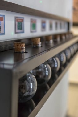 Mantar tıpalı birkaç eski iksir şişesi olan ahşap bir raf manzarası, kimyasal çözümler ve antik çağlarda başka kullanımlar için kullanılır....