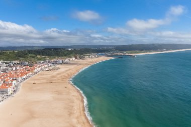 Fantastic aerial view of the beach and town of Nazare and the town from the viewpoint of the touristic old town of Nazare, atlantic ocean and sky, in Portugal
