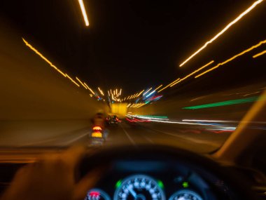 Zoom, gece vakti tünele motosikletle giren bir arabayı bulanıklaştırdı..