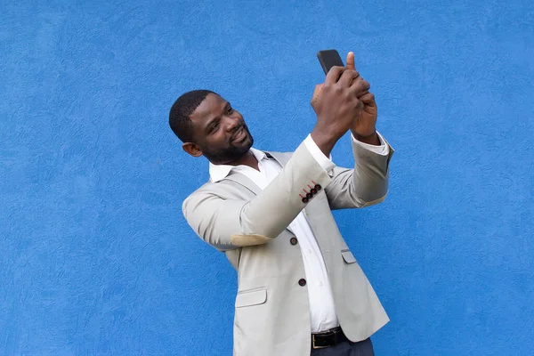 the happy African American with phone on blue background