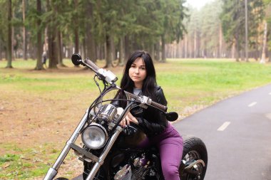 Pistteki motosikletli güzel esmer kadın.
