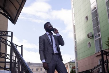 Bir iş adamı merdivenlerden inerken cep telefonuyla konuşur.