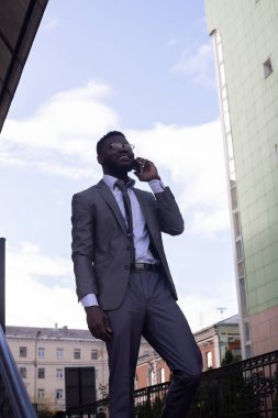 Bir iş adamı merdivenlerden inerken cep telefonuyla konuşur.