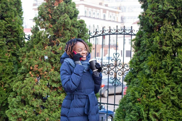 在街上拿着电话和咖啡的快乐的非洲裔美国女人 — 图库照片