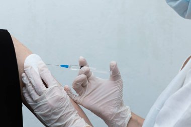 Hemşire hastayı aşılıyor, aşı oluyor.