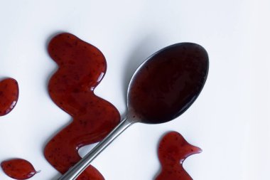 Beyaz arka planda ev yapımı sos ve kaşık.