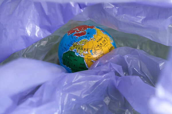 Земля день, глобус в мусорном мешке