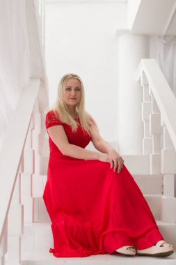 Stüdyoda kırmızı elbiseli güzel sarışın.