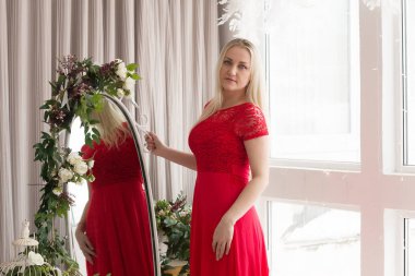 Stüdyoda kırmızı elbiseli güzel sarışın.