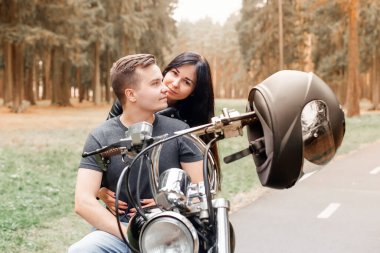 Parkta bir kızla motosikletli bir adam.