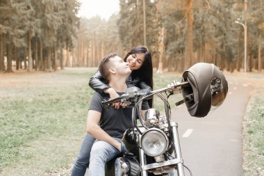 Parkta bir kızla motosikletli bir adam.