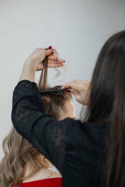 Usta bir kız için saç stili yapıyor, güzel bukleler.