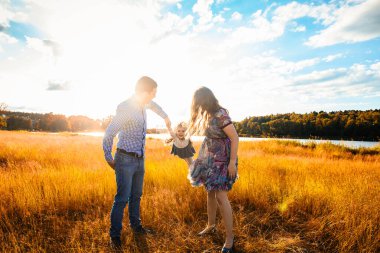 happy family at sunset, having fun with a child in nature.