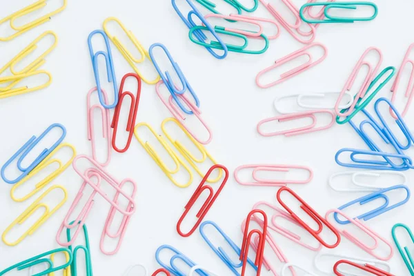 paper clips on a white background, scattered on the table.