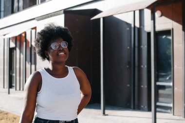 Mutlu Afrikalı Amerikalı kadın yazın sokakta yürüyor..