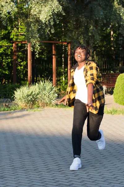 在公园里的一个快乐的非裔美国女人在夏天跳了一跳 — 图库照片