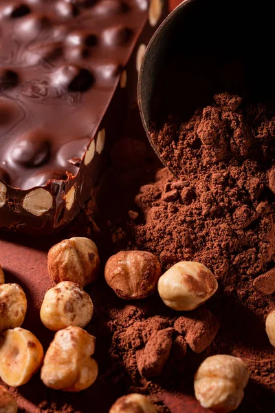 Förgrunden Kakaopulver Rostade Hasselnötter Och Ett Block Mörk Choklad Med — Stockfoto