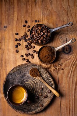 Kırsal ahşap arka planda, üst manzaralı, kavrulmuş kahve çekirdekleri ve bir fincan espresso..