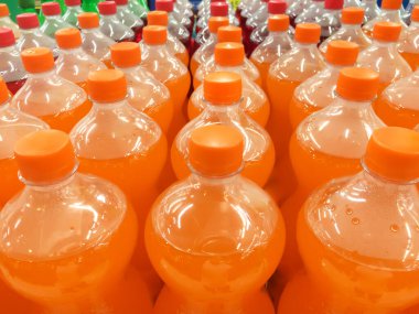 Bir marketin raflarında sergilenen meşrubat sıraları. Şişe kapağına odaklan..