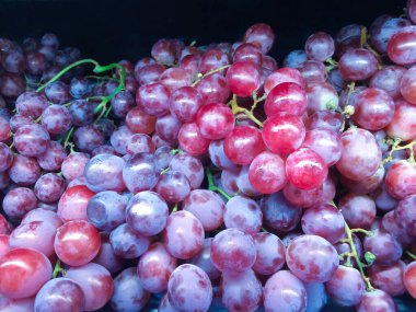 Marketteki meyve rafında olgun ve taze kırmızı üzümler. Seçici odak.