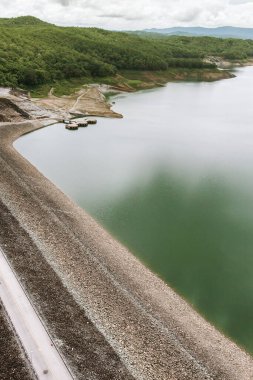 Arka planda bir set barajı, Nan Nehri rezervuarı ve yeşil tropikal orman havadan görülüyor. İklim değişikliği, çevre kavramları.
