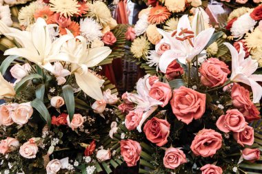 Caddedeki bir çiçekçide renkli çiçekler sergileniyor. Zambak, güller, karanfiller ve diğer çiçekler. Phnom Penh Şehri, Kamboçya.