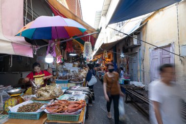 Phetchaburi, Tayland - 2 Ocak 2026: Islak pazarda günlük hayat, çeşitli tuzlu balık satan bir satıcı. Mueang Phetchaburi.