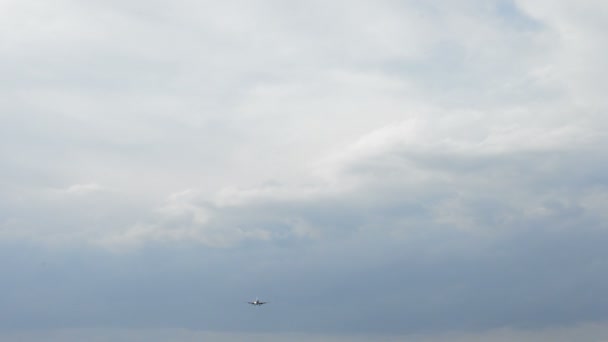 Flygplan som flyger på låg höjd landar i en molnig dag — Stockvideo