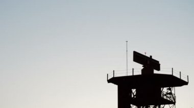 Gün batımında radar telekomünikasyon kule üzerinde kalkış uçak