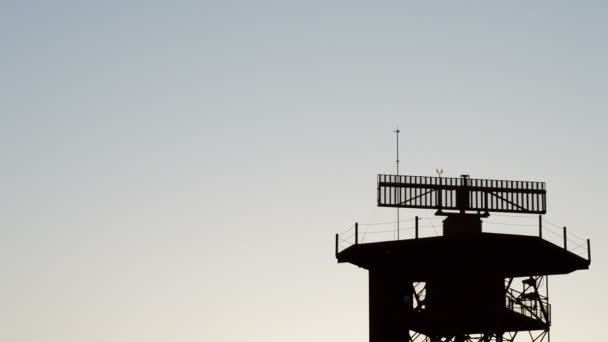 Giro de radar en torre de telecomunicaciones en aeropuerto al atardecer — Vídeos de Stock