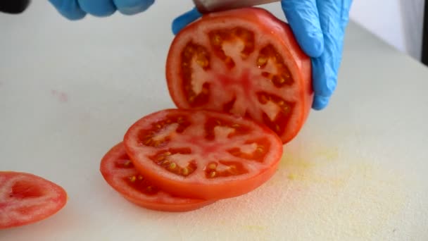 Chef-kok met een mes een tomaat fruit in kleine stukjes snijden — Stockvideo