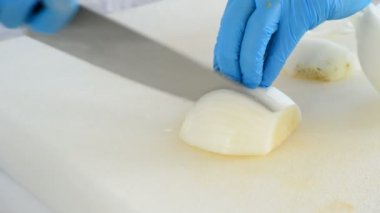 Elinde bir bıçakla bir oturum pişirme smalls parçalar halinde bir soğan kesilmesi Şef