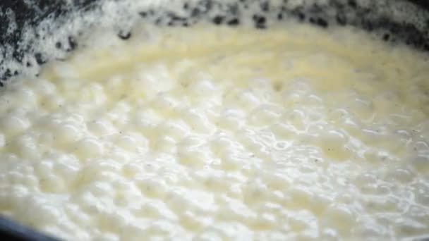 Bulles blanches crème bouillante dans une casserole — Video