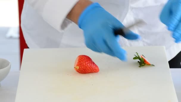 Hände des Küchenchefs kochen mit einer Erdbeere für ein Rezept in der Küche — Stockvideo