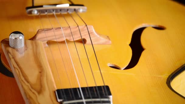 Detalhe de trastes, corda, corpo, boca e ponte de guitarra típica clássica espanhola girando em fundo preto — Vídeo de Stock