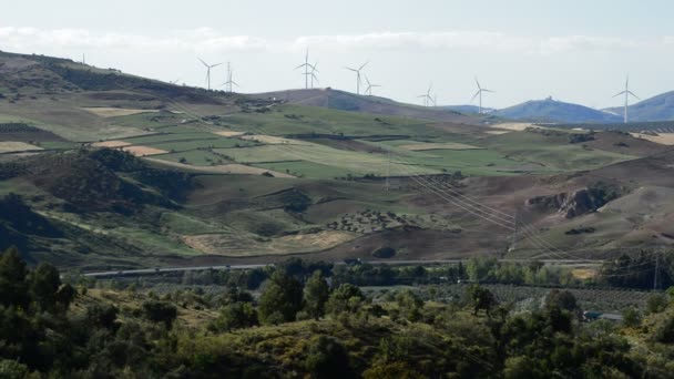 Energia das turbinas eólicas movendo-se na paisagem mediterrânea ao pôr do sol — Vídeo de Stock